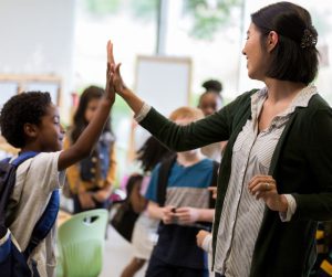 Female teacher giving a student a high five